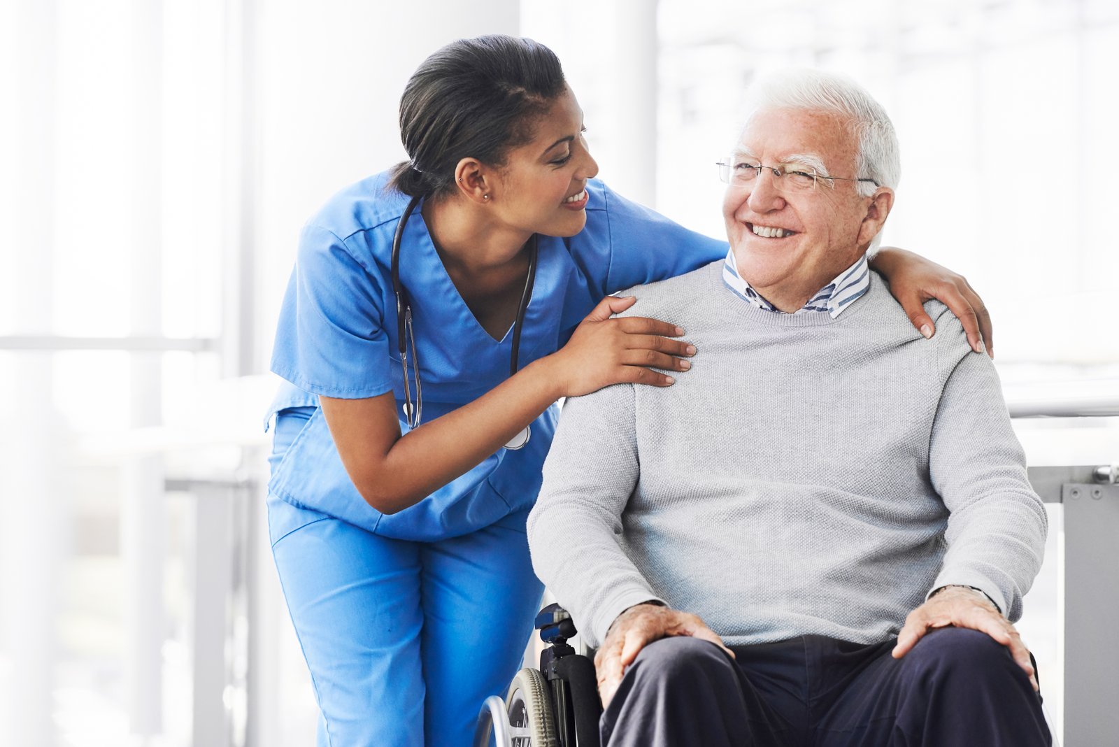 Aster Care Home Saskatoon-nuese laughing with old man in Aster Care Home Saskatoon-Saskatoon