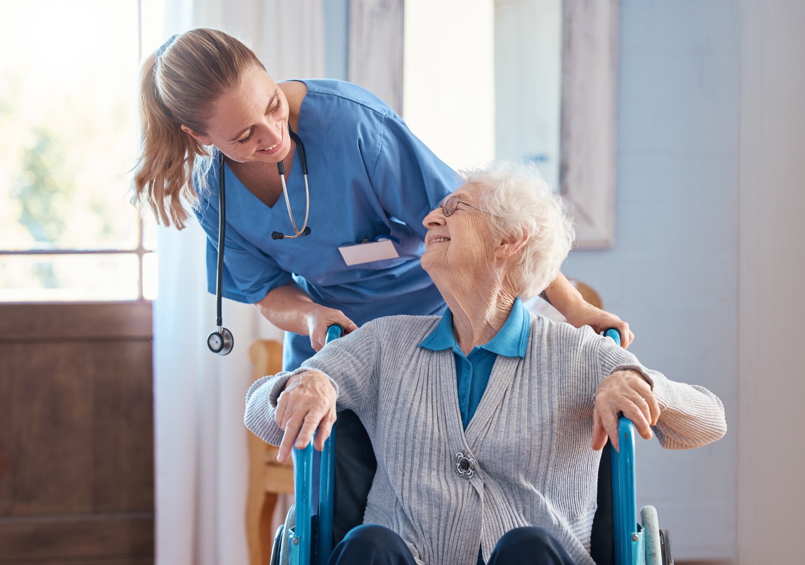 Aster Care Home Saskatoon mission-nurse talking to a old woman in wheelchair in Aster Care Home Saskatoon-saskatoo